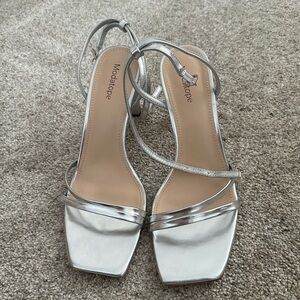 Silver strappy high heels with thick heel.